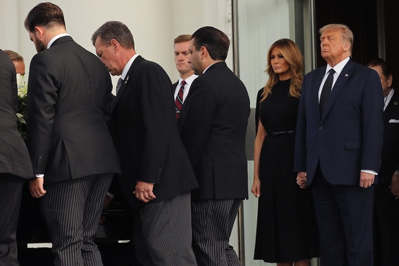 Тој потресен, таа го држи за рака: Меланија и Трамп на погребот на неговиот брат